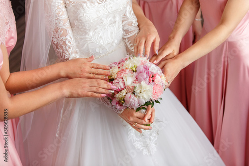 Bride and bridesmaids holding wedding bouquet