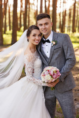 Wedding portrait of stylish newlyweds. Happy couple, bride and groom are smiling and looking at the camera. Classic wedding photo in a frame