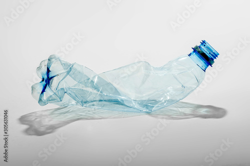 Crumpled plastic bottle on a light background. The concept of ecology