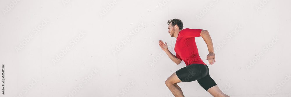 Running man runner training doing city run sprinting along wall outdoor white background. Male athlete profile doing sprint hiit high intensity interval training triathlon. Banner panorama.