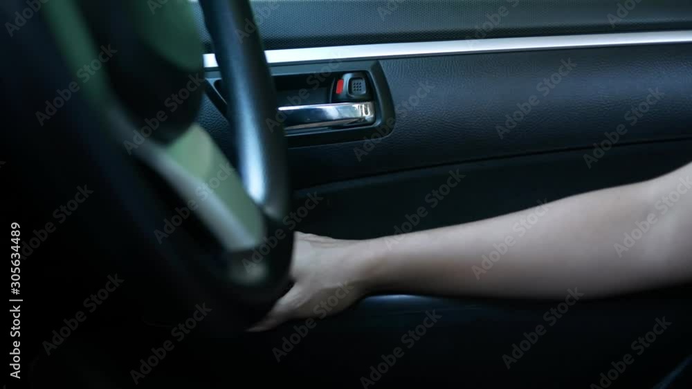 Close-up of Driver's hand closing the car door and pressing on button switch electric lock doors in car for safety. Technology and transportation concepts. Close-up of Driver's hand closing the car door and pressing on button switch electric lock doors in car for safety. Technology and transportation concepts.