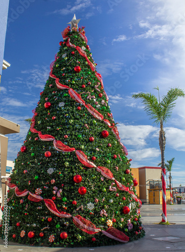 Giant Christmas tree with red and green Christmas spheres and colorful ribbons