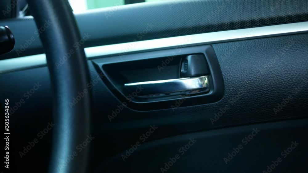 Close-up of switch electric lock doors working while driver's hand pressing button in car for safety. Technology and transportation concepts. Close-up of switch electric lock doors working while driver's hand pressing button in car for safety. Technology and transportation concepts.