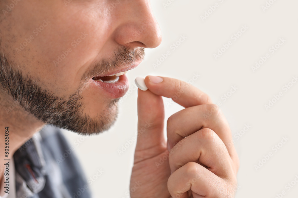 Man taking medicine at home, closeup Man taking medicine at home, closeup