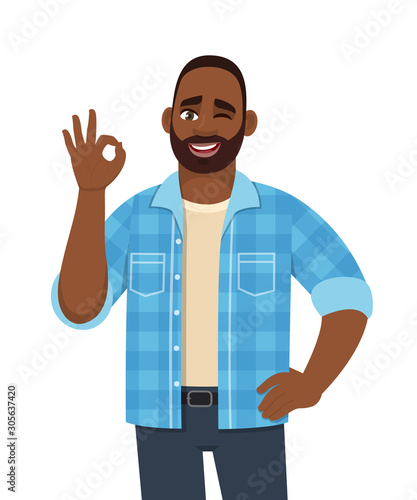 Happy young bearded African man showing okay, cool gesture with winking eye. Trendy successful black person making OK, good symbol. Male character design illustration in vector cartoon style.