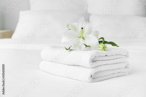 Fototapeta Naklejka Na Ścianę i Meble -  Clean soft towels and flowers on bed