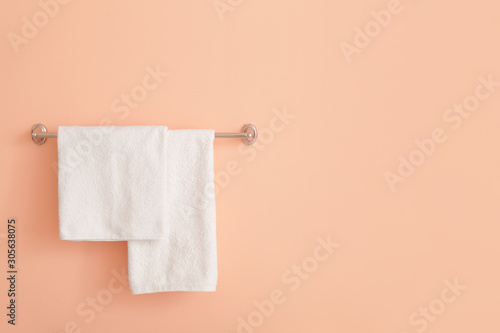 Soft towels hanging on color wall