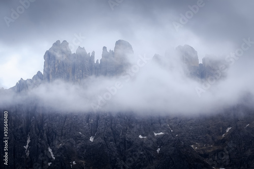 Mountain peak hiding behind the clouds and fog on the highland plateau in Dolomites, South Tyrol, Italy