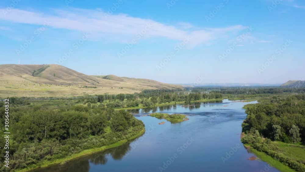 The long arms of the wild fresh river bed stretched along the beautiful mountains and green fields The long arms of the wild fresh river bed stretched along the beautiful mountains and green fields
