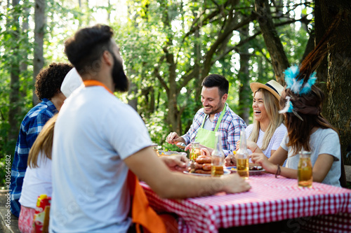 Group of happy young friends having barbecue party  outdoors