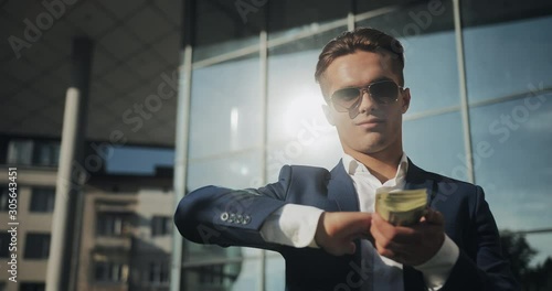 Young cocky businessman scattering money. photo