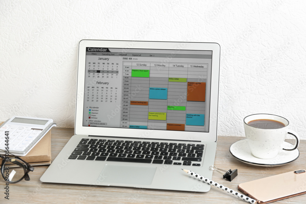 Modern laptop with calendar app in office Modern laptop with calendar app in office