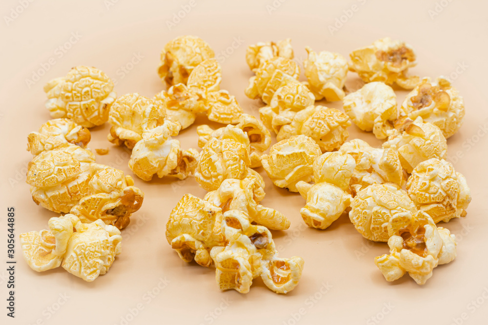 Delicious popcorn with caramel on color background