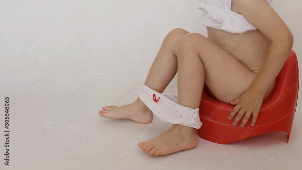 Little girl sits on a red pot. Accustoming to a toilet of children, background, hygiene Stock 비디오 | Adobe Stock 