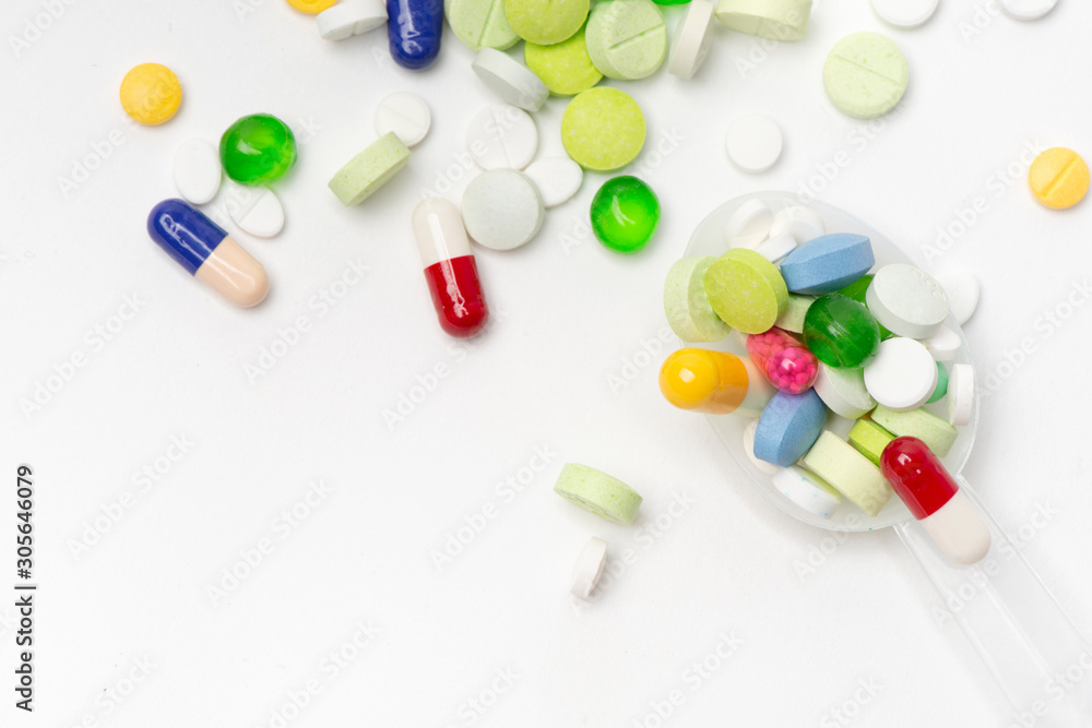 Top View of Colorful, Assorted pharmaceutical medicine pills. Many pills and tablets in white spoon isolated on white background with copy space. medicine concept