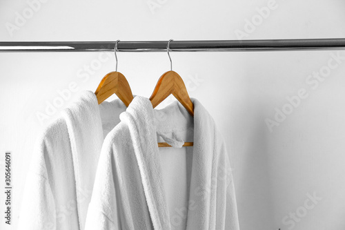 Soft comfortable bathrobes hanging on rack in closet
