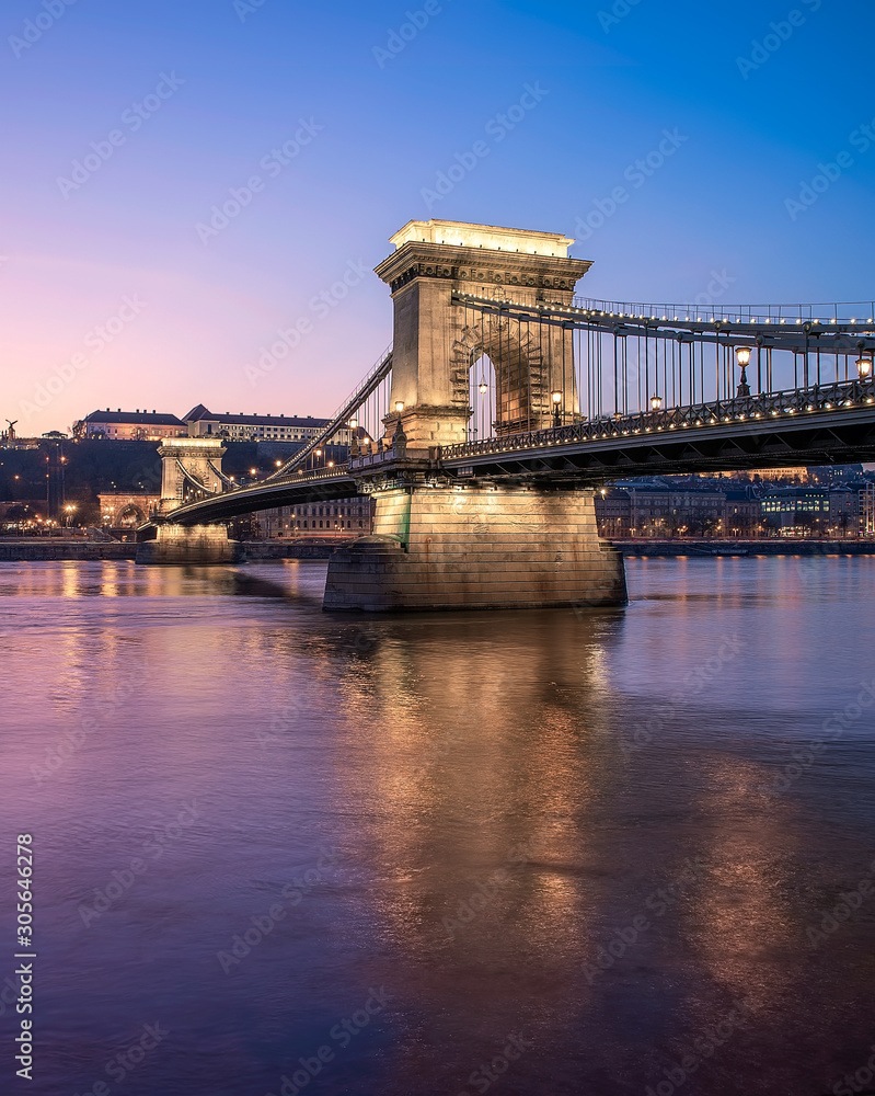 Amazing photo about Szechenyi Chain bridge with danube river. Splendid purple sunset lights. Budapest, Hungary.