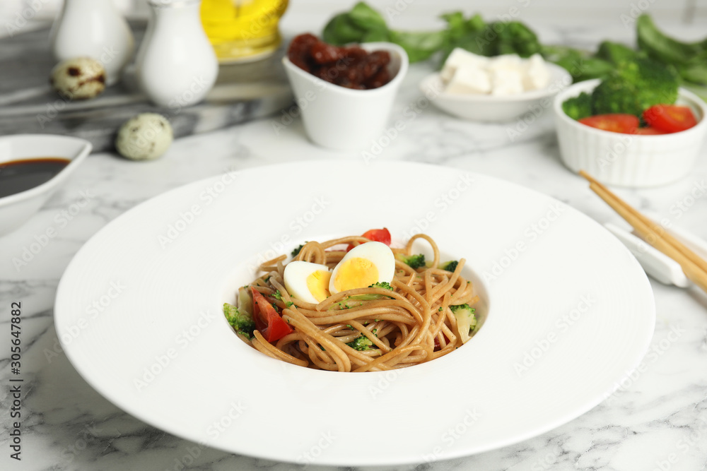Tasty buckwheat noodles served on white marble table Tasty buckwheat noodles served on white marble table