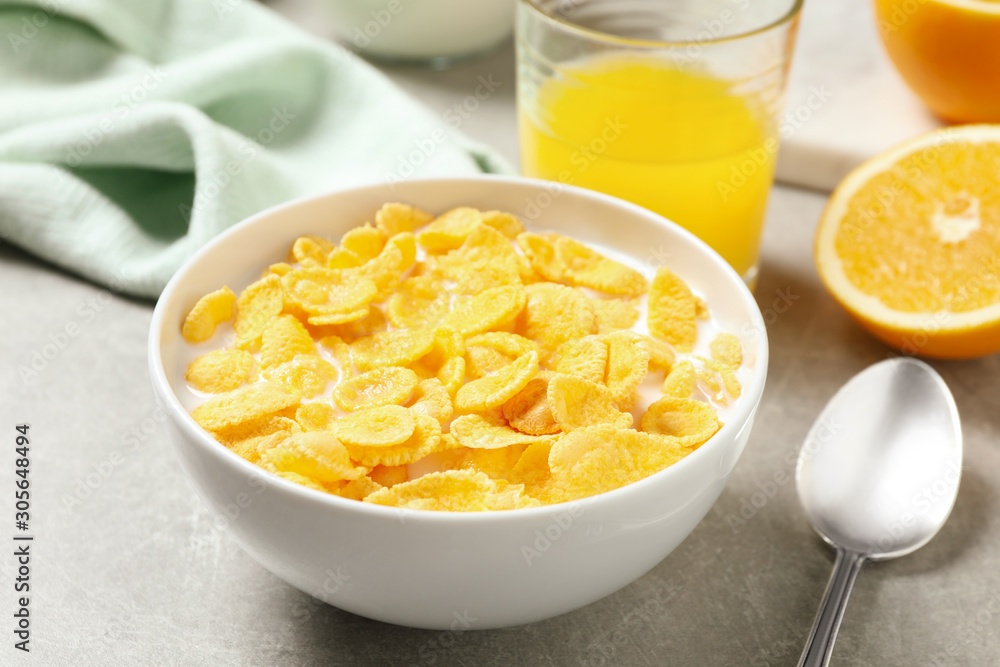 Tasty corn flakes with milk on light grey table Tasty corn flakes with milk on light grey table