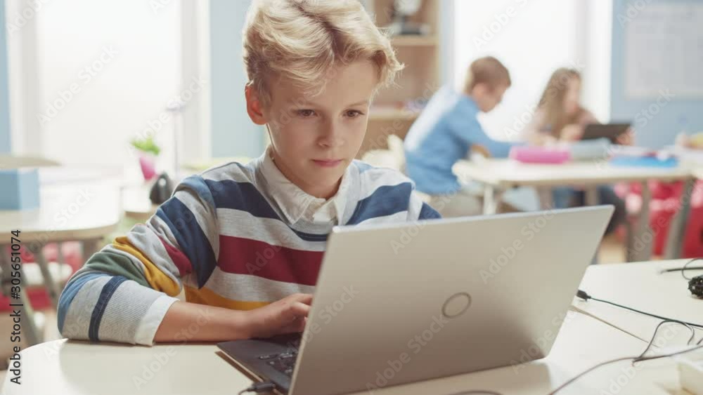 Smart Schoolboy Uses Laptop to Program Software for Robotics Engineering Class. Elementary School Science Classroom with Gifted Brilliant Children Working with Technology Smart Schoolboy Uses Laptop to Program Software for Robotics Engineering Class. Elementary School Science Classroom with Gifted Brilliant Children Working with Technology