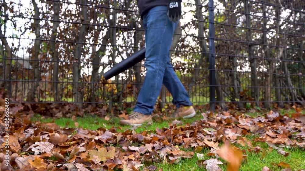 Worker blowing messy leaves in autumn season in slow motion. Worker blowing messy leaves in autumn season in slow motion.