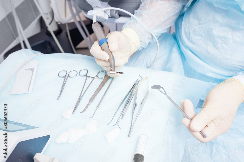 During the operation, the dentist holds implantation tools During the operation, the dentist holds implantation tools