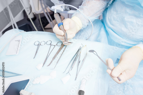 During the operation  the dentist holds implantation tools