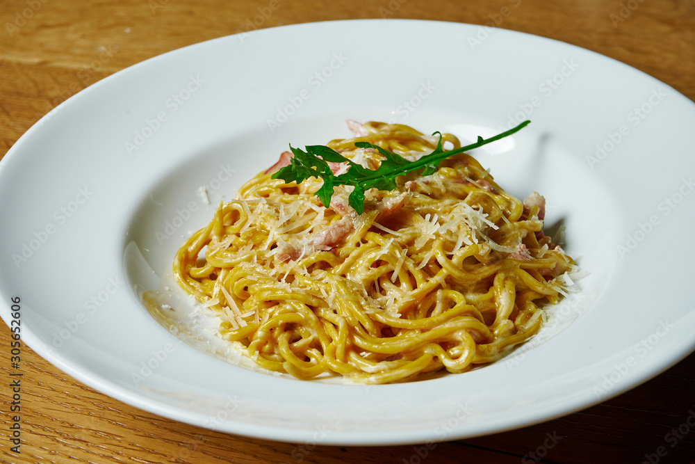 Homemade Italian pasta in creamy sauce, bacon and parmesan in a white plate. Italian Cuisine. Close up. Tasty food photo background Homemade Italian pasta in creamy sauce, bacon and parmesan in a white plate. Italian Cuisine. Close up. Tasty food photo background