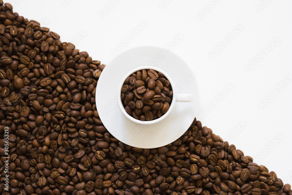 Fototapeta premium white cup on coffee beans on a white background, top view