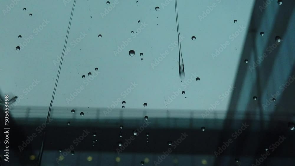 The rain drops falling on the windows very slowly, refreshing and reviving the view. Slow movement of raindrops on window glass The rain drops falling on the windows very slowly, refreshing and reviving the view. Slow movement of raindrops on window glass
