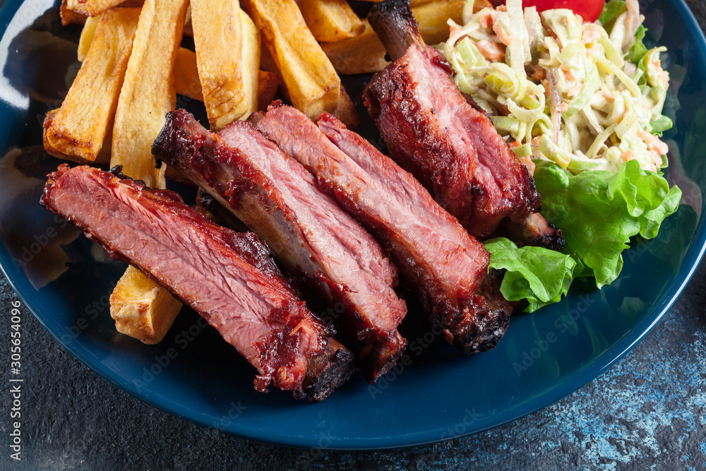 Spicy barbecued pork ribs served with french fries