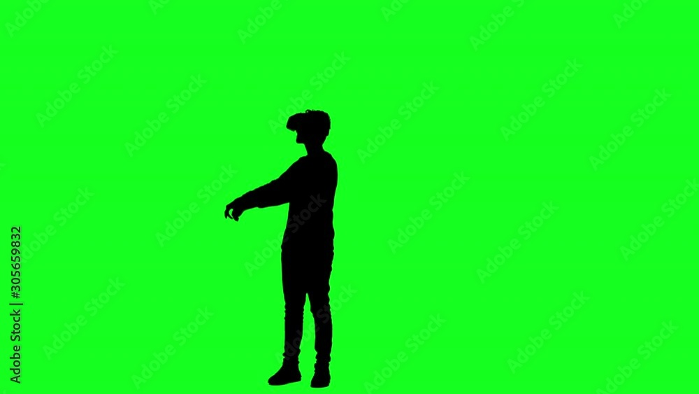 Silhouette of a man wearing VR glasses playing a game on green screen Silhouette of a man wearing VR glasses playing a game on green screen