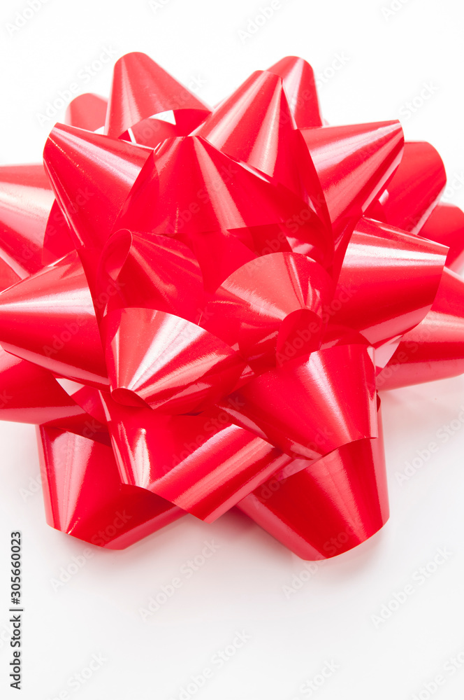Close-up of large shiny bright red gift bow in on white background Close-up of large shiny bright red gift bow in on white background