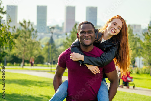 Tablou pe pânză Portrait of young man hugging his girlfriend standing together on a spring summe