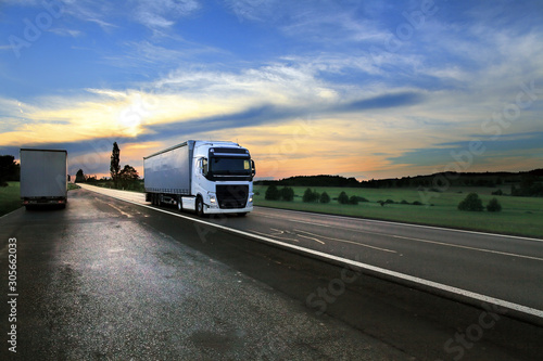 White truck transport on the road and cargo at sunset