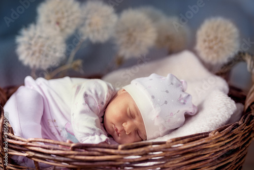 Baby sleeps in a wicker basket.