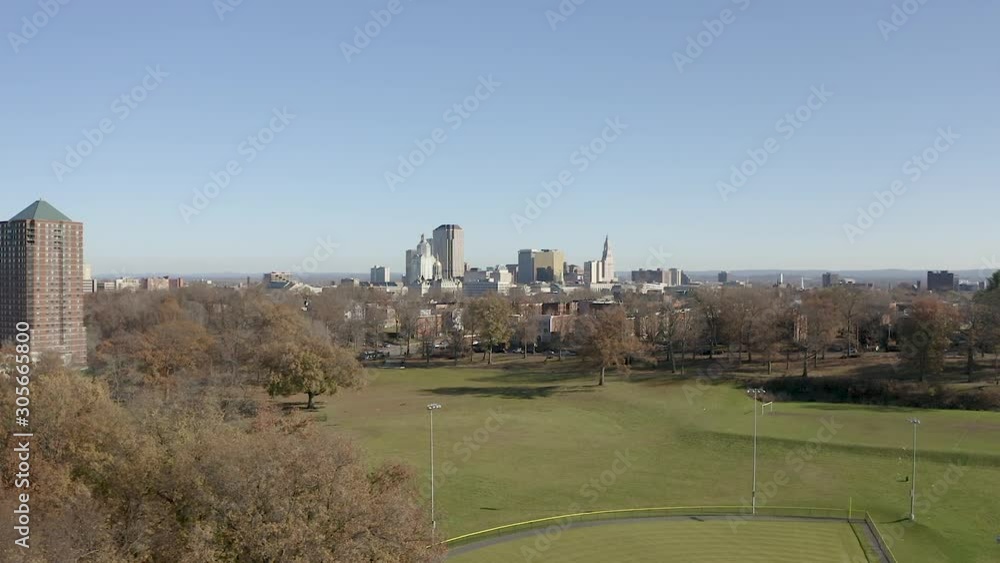 Aerial drone over park with Downtown Hartford cityscape in background RAW minimal color grade Aerial drone over park with Downtown Hartford cityscape in background RAW minimal color grade