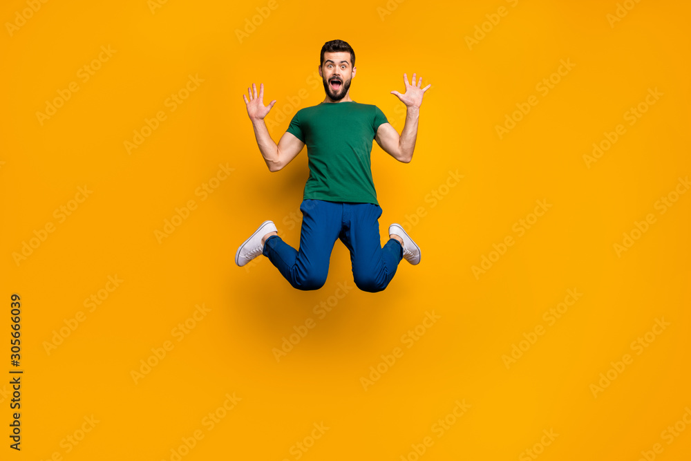 Full size photo of astonished guy hear wonderful black friday discounts information impressed jump scream wow omg wear modern youth clothing isolated over yellow color background