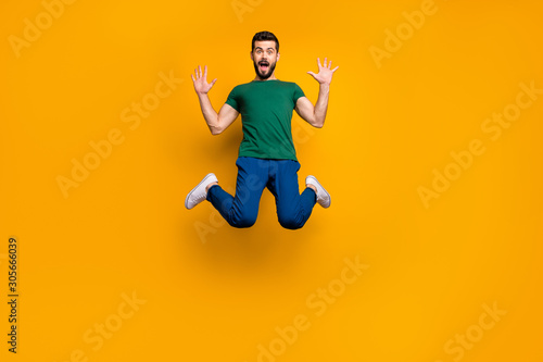 Full size photo of astonished guy hear wonderful black friday discounts information impressed jump scream wow omg wear modern youth clothing isolated over yellow color background © deagreez
