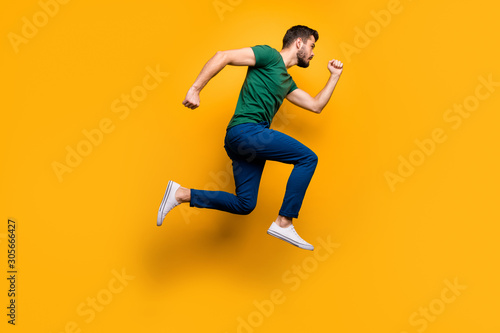 Full length profile side photo of serious focused guy jump run fast want buy spring black friday discounts wear casual style outfit isolated over yellow color background