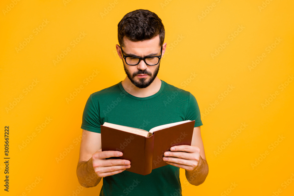 Portrait of focused college student guy hold read textbook learn information for study project wear spectacles good looking clothes isolated over yellow color background Portrait of focused college student guy hold read textbook learn information for study project wear spectacles good looking clothes isolated over yellow color background
