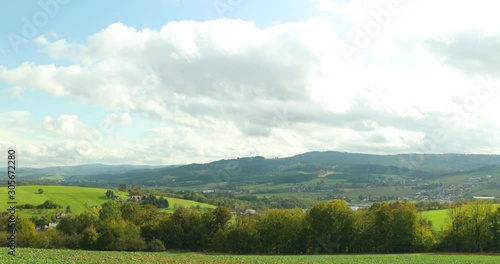 Wallpaper Mural Moving clouds over the village and their shadows reflect on the ground above the landscape and field in the Beskid National Park area, background of high hills during a sunny day captured in 4k 60fps Torontodigital.ca