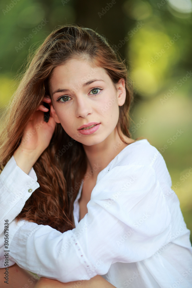 Jolie jeune femme assise sous un arbre souriante Jolie jeune femme assise sous un arbre souriante