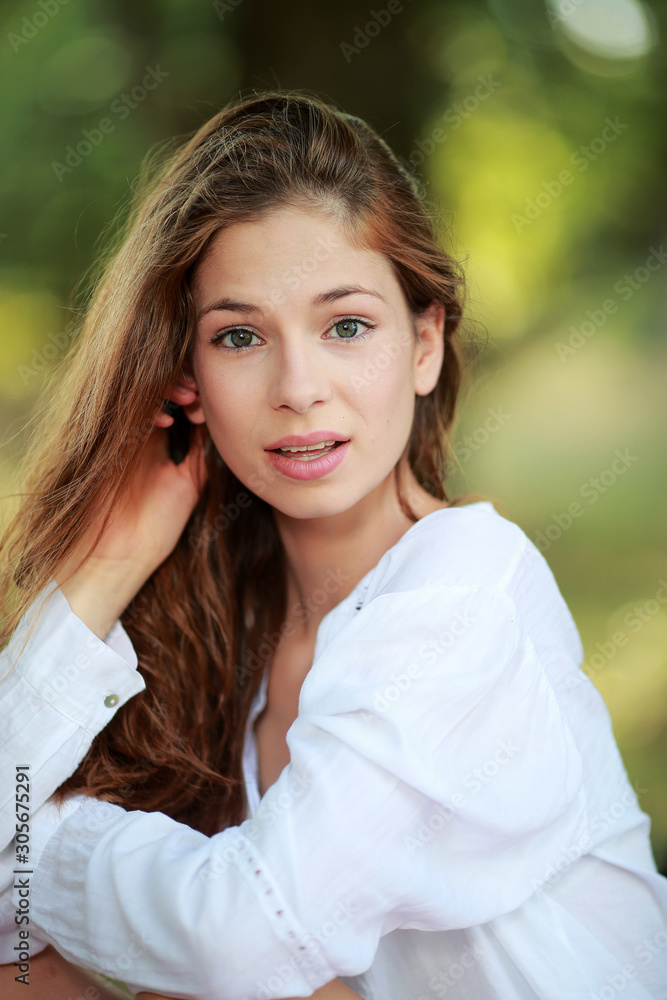 Jolie jeune femme assise sous un arbre souriante Jolie jeune femme assise sous un arbre souriante