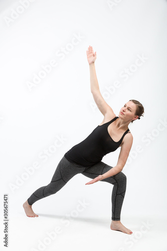 woman in gym clothes is doing some streching exercises