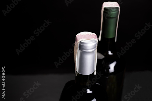 Two bottles of wine with excise tax band. A studio photo on a black background, top view.