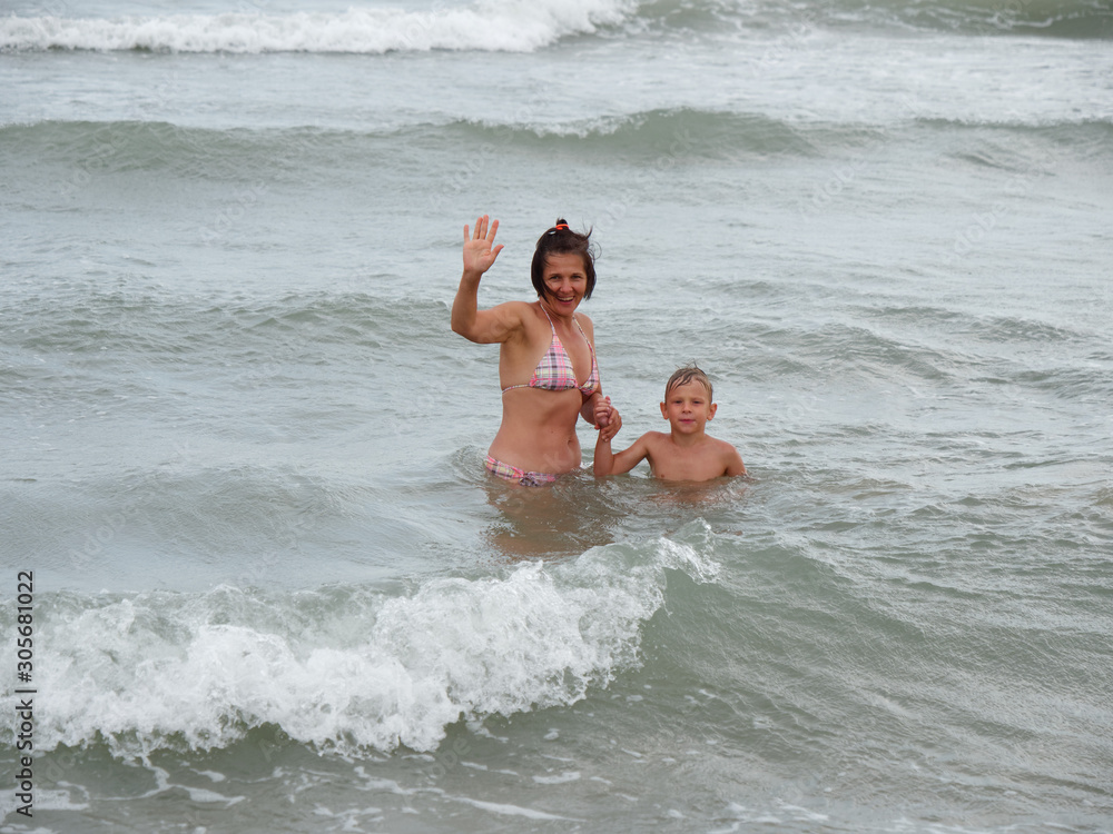 mom and son are swimming in the sea. Bibione, Italy