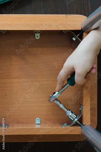 Hands screwing a screw with...