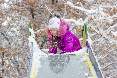 Kid girl on children slide ...