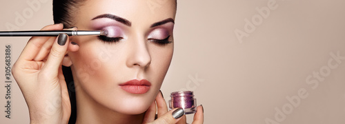 Makeup artist applies eye shadow. Beautiful woman face. Perfect makeup.  Makeup detail. Beauty girl with perfect skin. Nails and manicure - Obraz na  szkle - decoPLANET